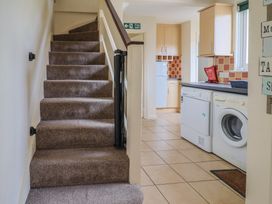 A kitchen with stairs leading to an upper floor at Court House Farmhouse in Charmouth