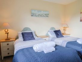 A bedroom with twin beds and a nightstand at Court House Farmhouse in Charmouth