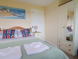 A bedroom with a bed and wardrobe at Court House Farmhouse in Charmouth