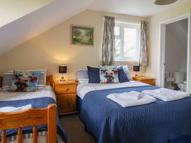 A bedroom with two beds and a window at Court House Farmhouse Charmouth