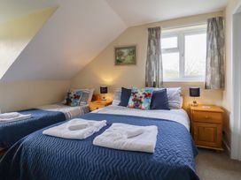 A bedroom with two beds and a nightstand at Court House Farmhouse in Charmouth