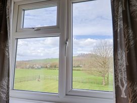 A window view showing a field and trees at Court House Farmhouse in Charmouth