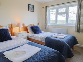 A bedroom with two beds and a lamp at Court House Farmhouse in Charmouth
