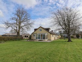 A house with outdoor seating and trees at Court House Farmhouse in Charmouth