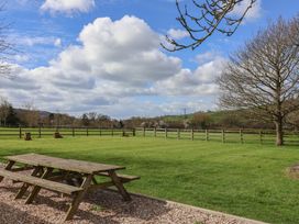 An outdoor area with a picnic table and trees at Court House Farmhouse in Charmouth