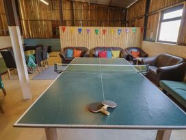 A game room with a ping pong table and couches at Court House Farmhouse in Charmouth