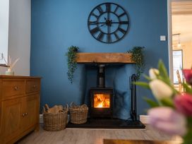A living room with a fireplace and wooden mantel at Garn View in Dolgellau
