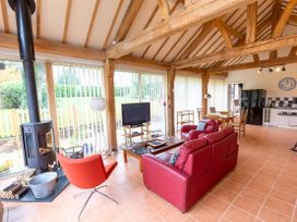A living room with a sofa, coffee table, and television at Nature's Lodge in Cookley