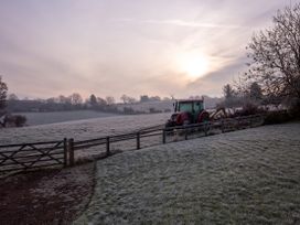 A tractor near a fence in a frosty field at Nature's Lodge in Cookley
