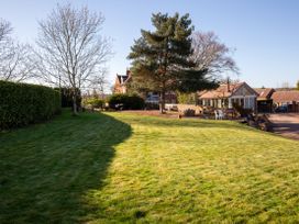 A garden with grass and trees at Nature's Lodge in Cookley