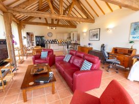 A living room with a sofa and dining area at Nature's Lodge in Cookley