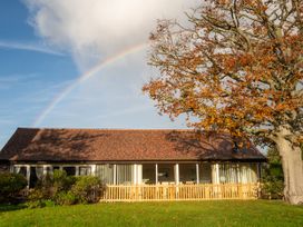 A house with a fence and tree under a rainbow at Nature's Lodge in Cookley