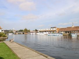 A riverside view with boats and buildings at Cotman Cottage Norwich