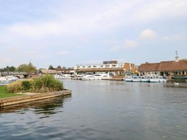 A waterway with boats and a hotel at Cotman Cottage Norwich