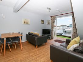 A living room with a view of a marina at Cotman Cottage in Hoveton & Wroxham