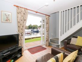 A living room with a view of boats outside at Cotman Cottage in Hoveton & Wroxham