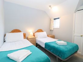 A bedroom with twin beds and a side table at Cotman Cottage Hoveton & Wroxham