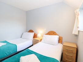 A bedroom with two single beds and a lamp at Cotman Cottage in Hoveton & Wroxham