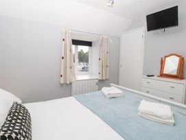 A bedroom with a bed and a television at Cotman Cottage in Hoveton & Wroxham