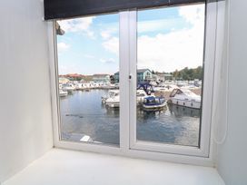 A view of a marina with boats from a window at Cotman Cottage Hoveton & Wroxham