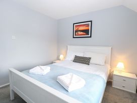 A bedroom with a bed and bedside lamps at Cotman Cottage in Hoveton & Wroxham