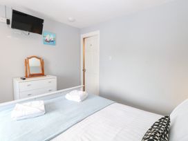 A bedroom with a bed and a mirror at Cotman Cottage in Hoveton & Wroxham