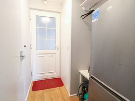 A hallway with a refrigerator and a door at Cotman Cottage Hoveton & Wroxham