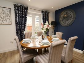 A dining room with a table set and a clock at 6 Upperfield Street Dolgellau
