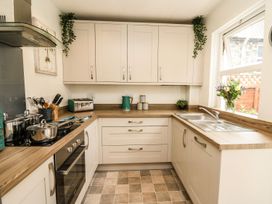 A kitchen with cabinets, sink, and cooking pots at 6 Upperfield Street Dolgellau