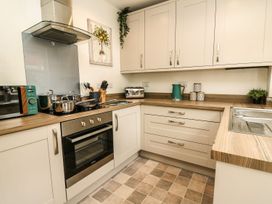 A kitchen featuring an oven, stove, sink, and cabinets at 6 Upperfield Street Dolgellau