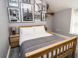A bedroom with a wooden bed and wall art at 6 Upperfield Street Dolgellau