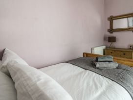 A bedroom with a bed and towels on top at 6 Upperfield Street in Dolgellau