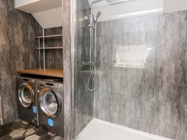 A laundry room with a washing machine, dryer, and shower at 6 Upperfield Street Dolgellau