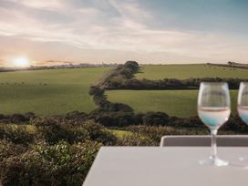 A view of a green field with glasses on a table at Polview in Newquay