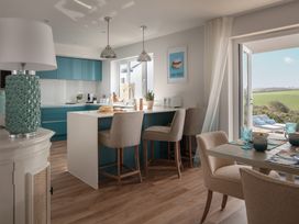 A kitchen with bar stools and a table at Polview in Newquay