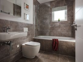A bathroom with a sink, toilet, bathtub, and shower at Polview in Newquay