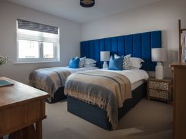 A bedroom with two beds and a table at Polview in Newquay
