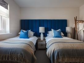 A bedroom with two beds and lamps at Polview in Newquay