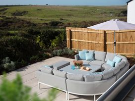 An outdoor seating area with a sectional sofa and table at Polview in Newquay