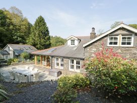 A house with a dining table and chairs in the garden at Bobbin Mill Cottage Ulverston