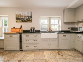 A kitchen with cabinets, sink, and microwave at Bobbin Mill Cottage, Ulverston