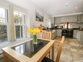 A kitchen with a table and flowers at Bobbin Mill Cottage in Ulverston