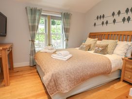 A bedroom with a double bed and television at Bobbin Mill Cottage in Ulverston