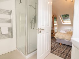A bathroom with a shower and bed area at Bobbin Mill Cottage in Ulverston