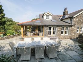An outdoor seating area with a table and chairs at Bobbin Mill Cottage in Ulverston
