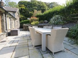 A garden with a patio set and plants at Bobbin Mill Cottage in Ulverston