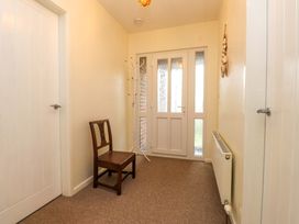 A hallway with a chair and coat rack at Gelli - Morfa Nefyn, Morfa Nefyn