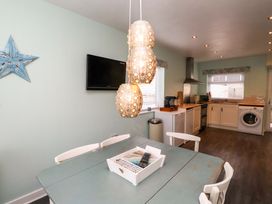 A kitchen with a table and chairs at Gelli - Morfa Nefyn in Morfa Nefyn