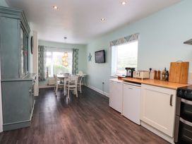A kitchen with a dining table and chairs at Gelli - Morfa Nefyn in Morfa Nefyn