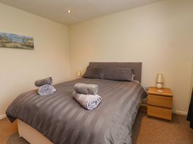 A bedroom with a bed and bedside table at Gelli - Morfa Nefyn